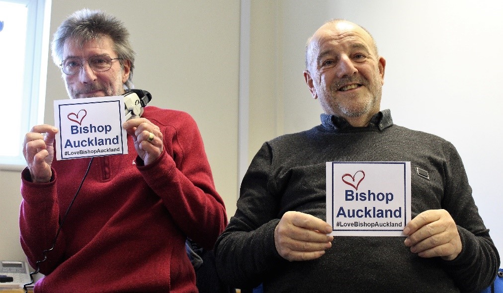 Mayor David Fleming at Bishop FM Radio Station with host Gary Burgham, holding #LoveBishopAuckland cards