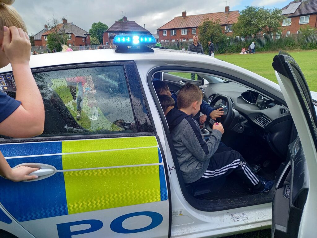 Children looking at the Police Car with the PCSO’s in attendance using the sirens and lights. 